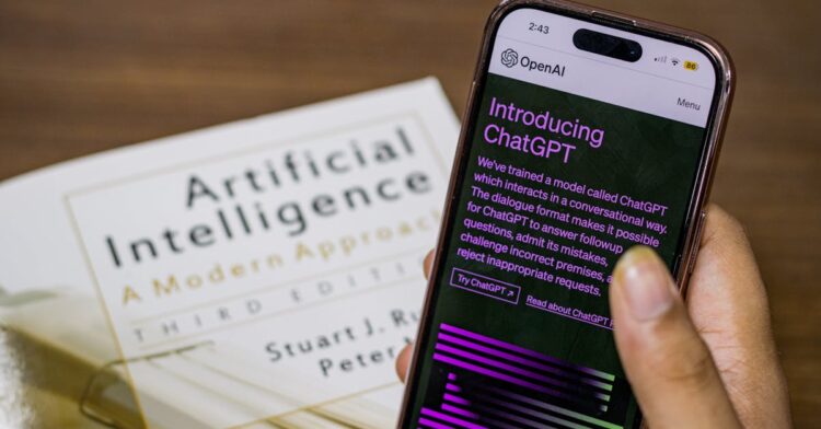 The 5 Best Books for Learning Machine Learning Mathematics Close-up of a smartphone displaying ChatGPT app held over AI textbook.
